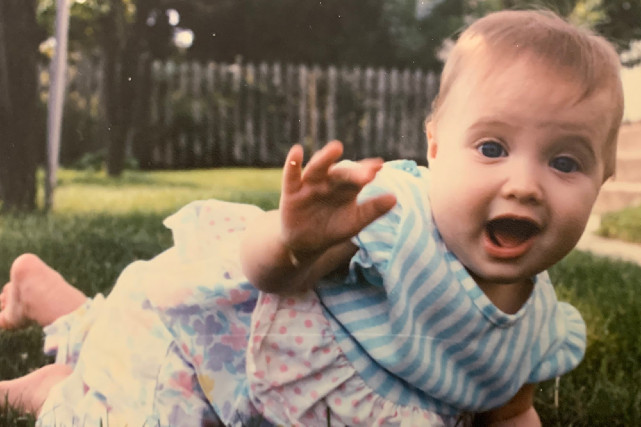 Baby plays in grass and poses for camera