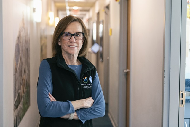 Female clinician stands in hallway of practice