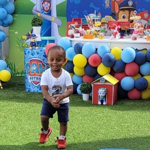 a boy playing in front of paw patrol balloons