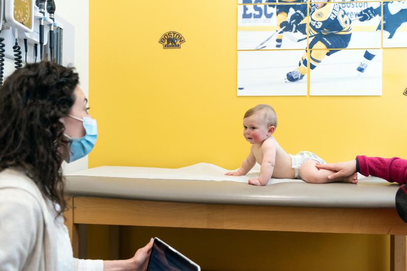 a mother watching her baby on an exam table